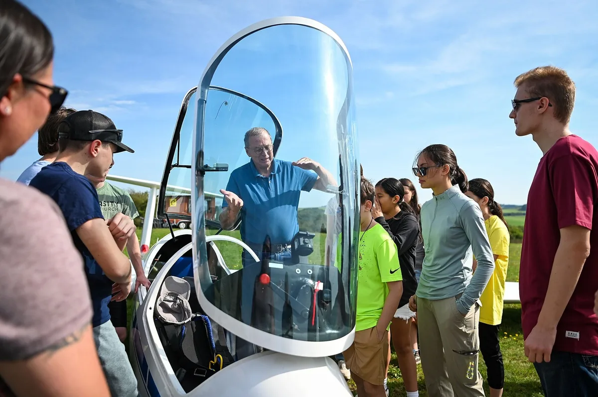 Au bord d'un terrain de vol à voile, en Allemagne, un instructeur montre les commandes d'un planeur à un groupe de jeunes. Photo : US Air Force, domaine public