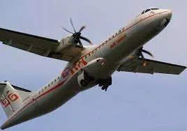 Photo en contre-plongée d’un avion de ligne bimoteur à hélices en montée, les deux turbopropulseurs montés sous une aile haute
