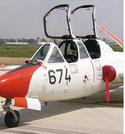 Photographie de l’avant d’un avion biplace au sol, poste de pilotage ouvert